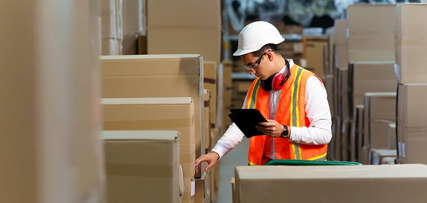 A warehouse worker checks the products stacked in the warehouse
